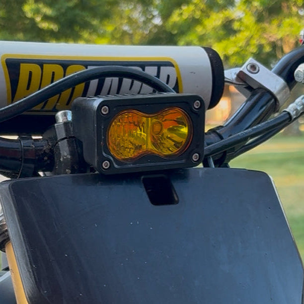 Motorcycle handlebar with ProBoltz mount and light, outdoor background
