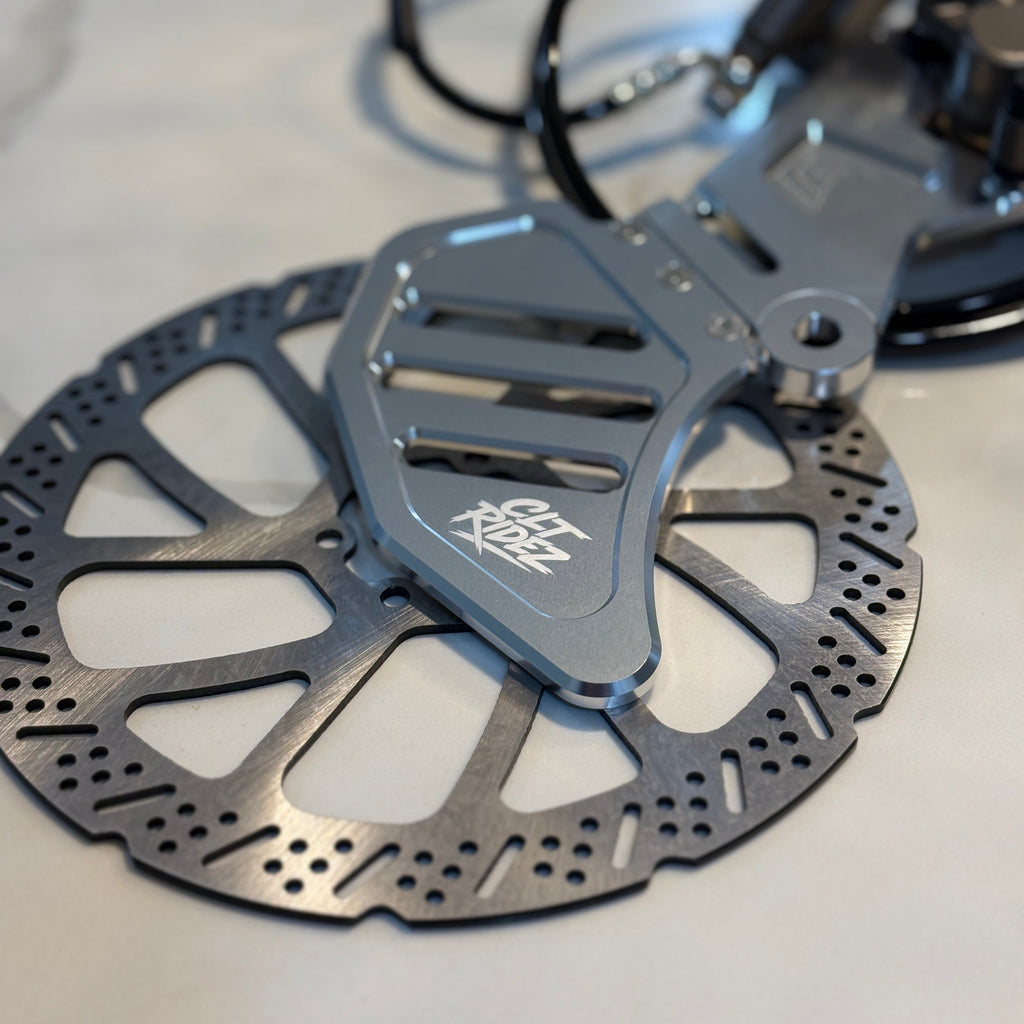 Bicycle disc brake rotor with caliper on a light background