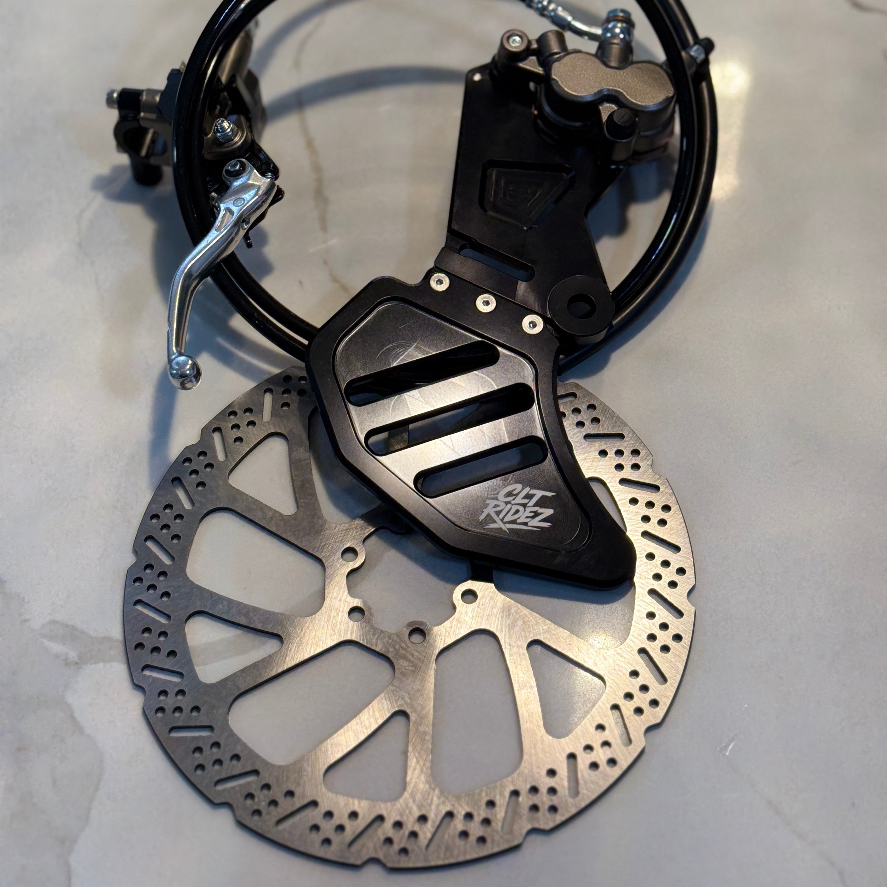Motorcycle brake disc and caliper on a light gray background