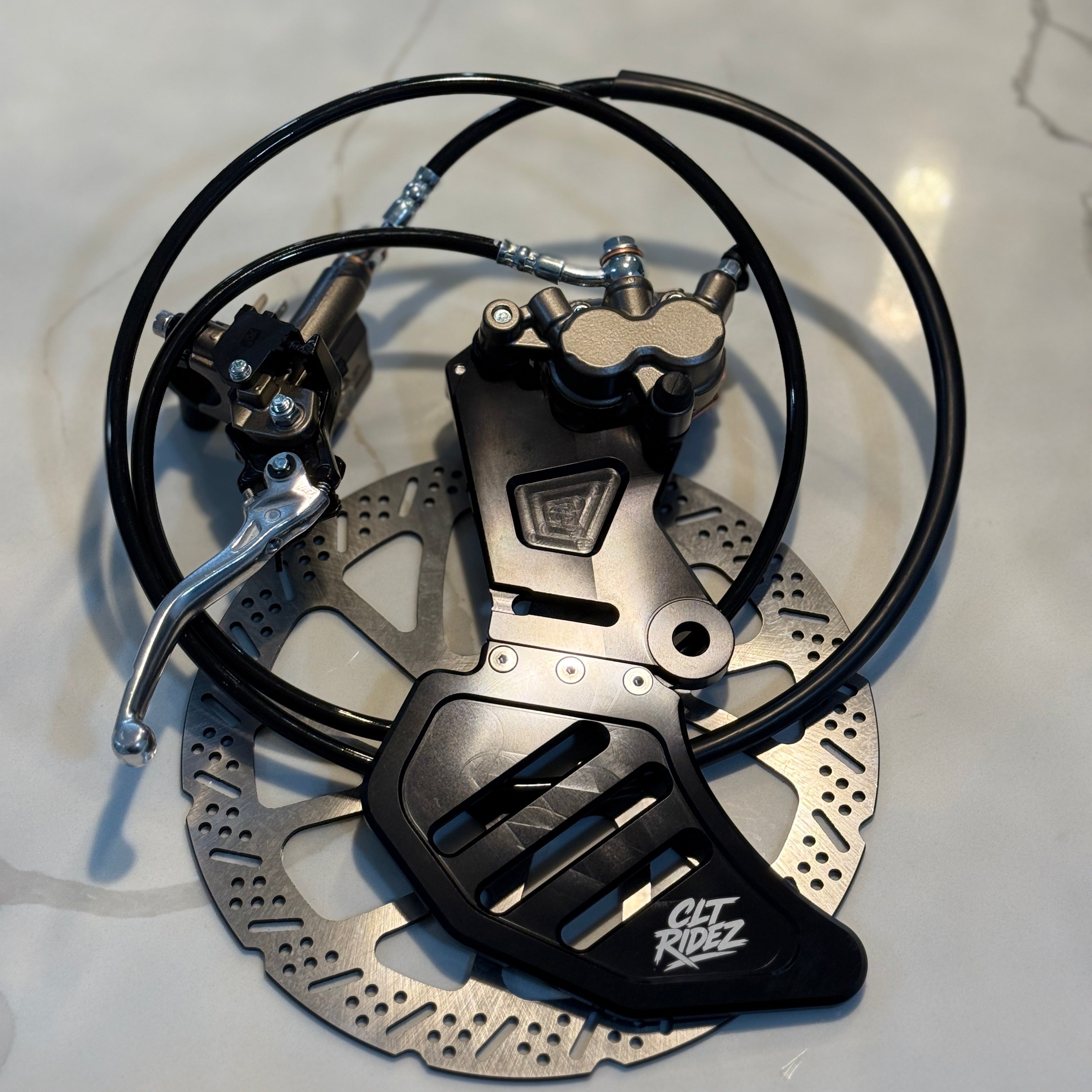 Bicycle brake system with disc and caliper on a light gray background
