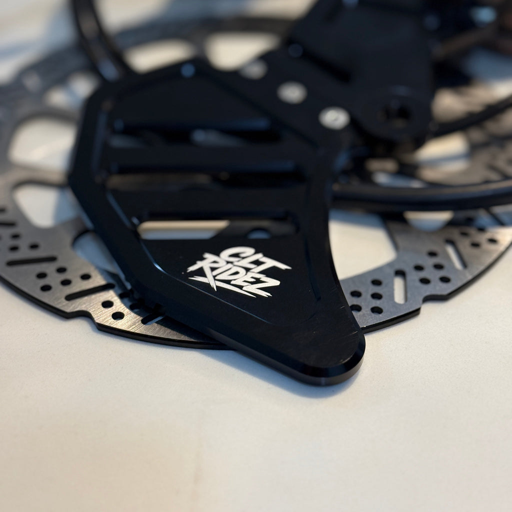 Close-up of a black bicycle disc brake rotor with a brand logo on a white background