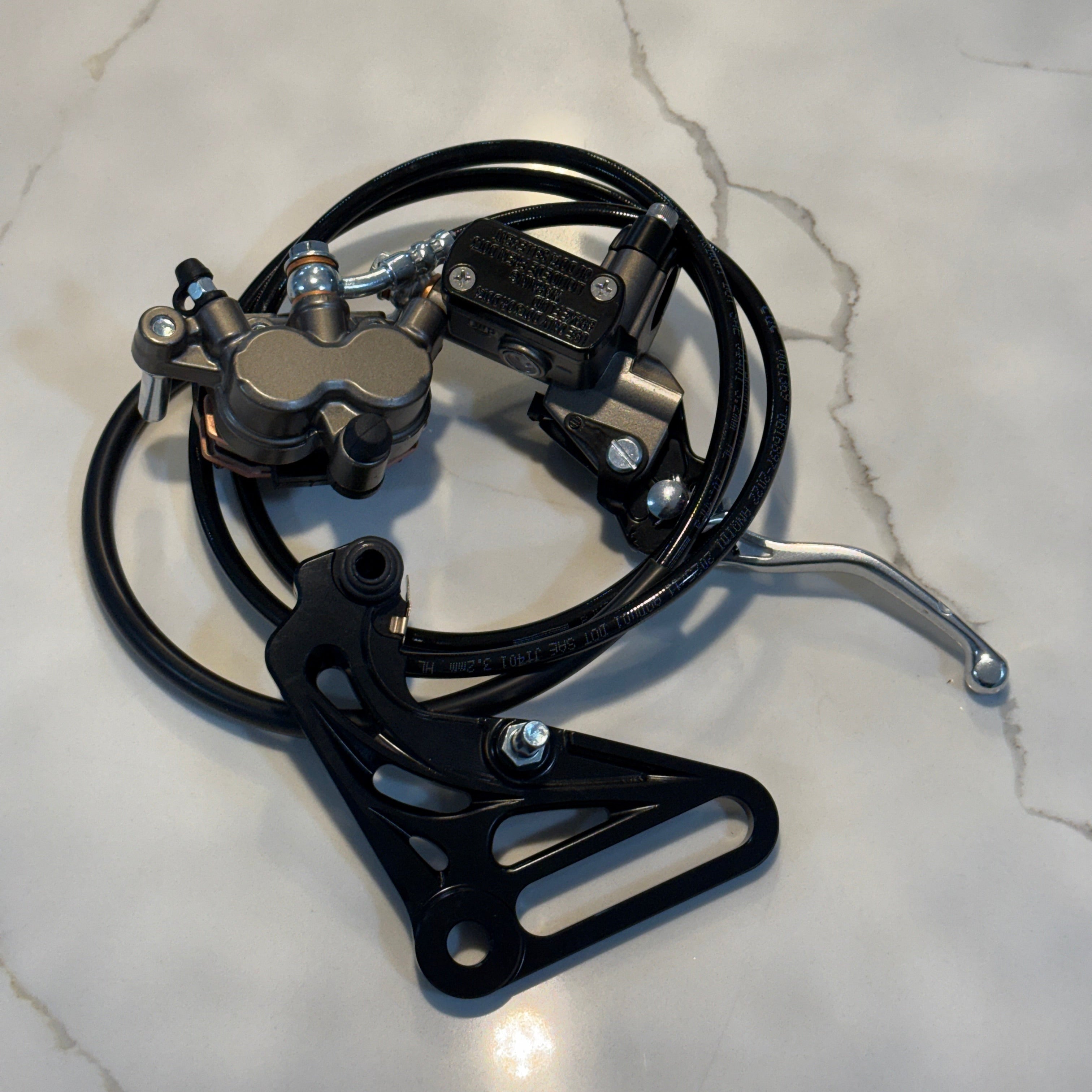 Motorcycle brake lever and caliper assembly on a marble surface