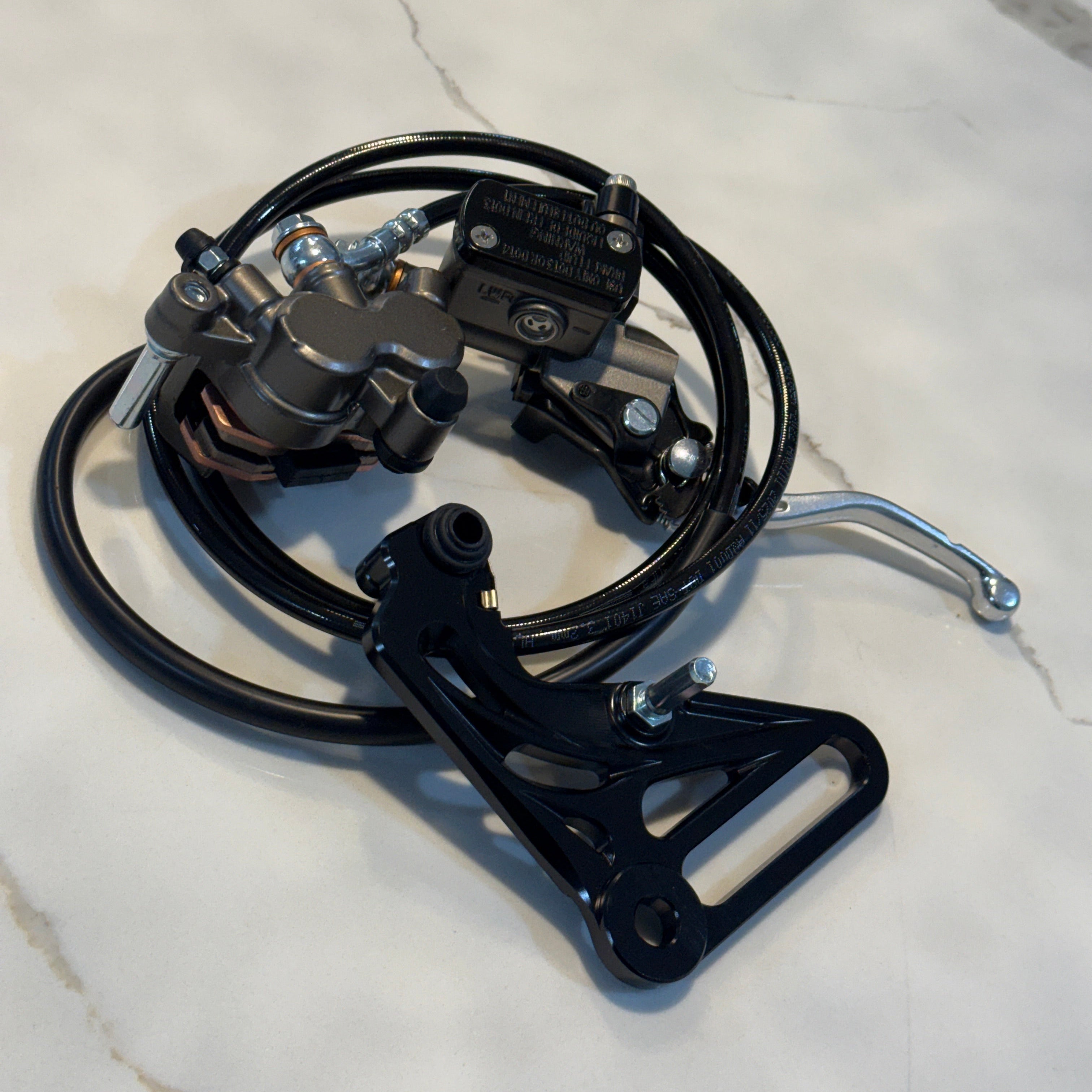 Motorcycle brake lever and caliper assembly on a marble surface