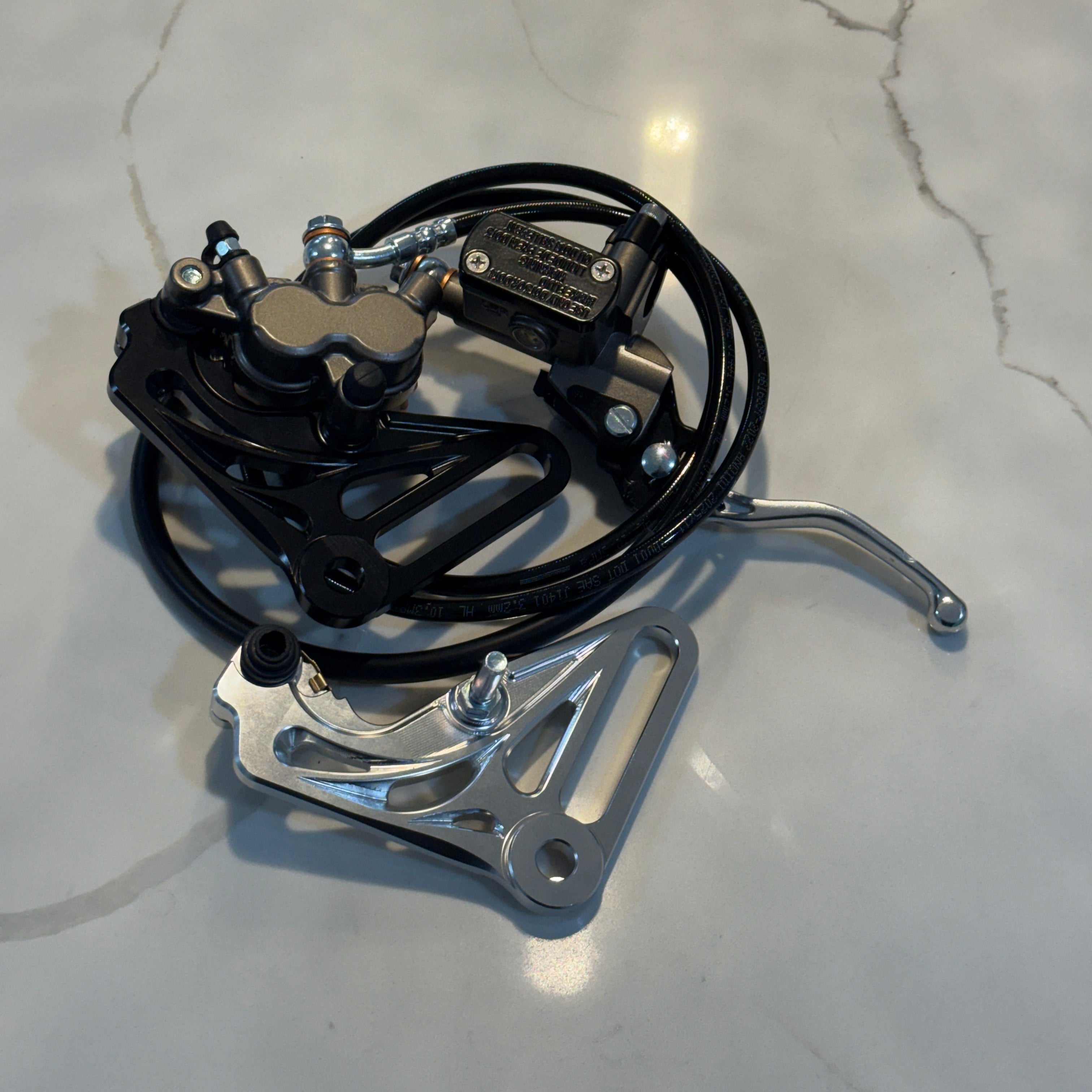 Mechanical component with black cable and metal parts on a marble surface