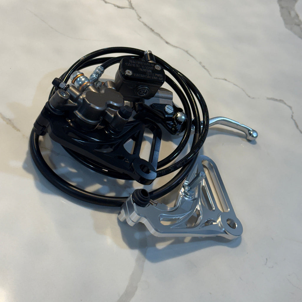 Mechanical device with black cables and metal components on a light gray surface