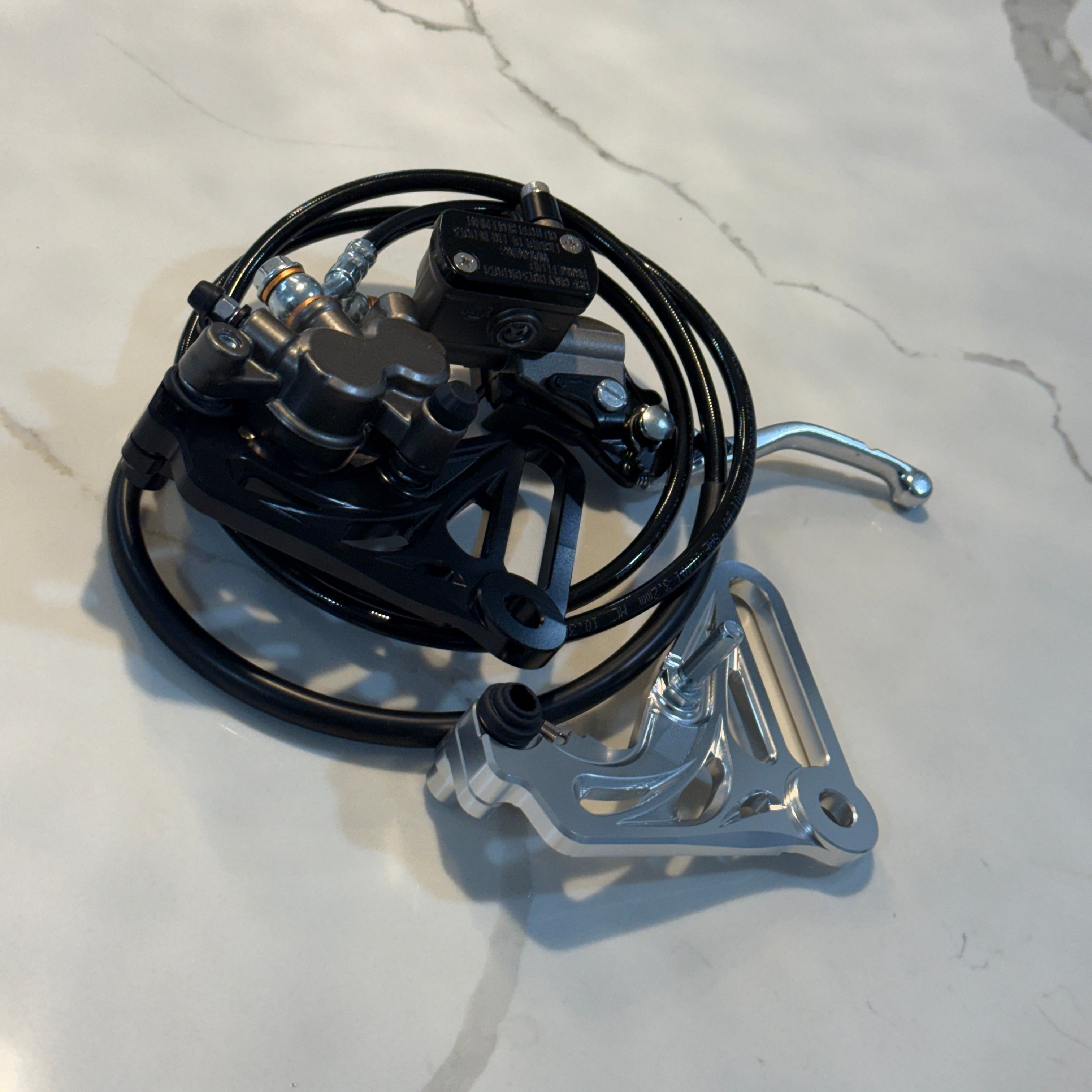 Mechanical device with black cables and metal components on a light gray surface