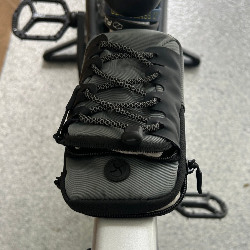 Gray bicycle seat bag attached to a bike seat with a blurred background
