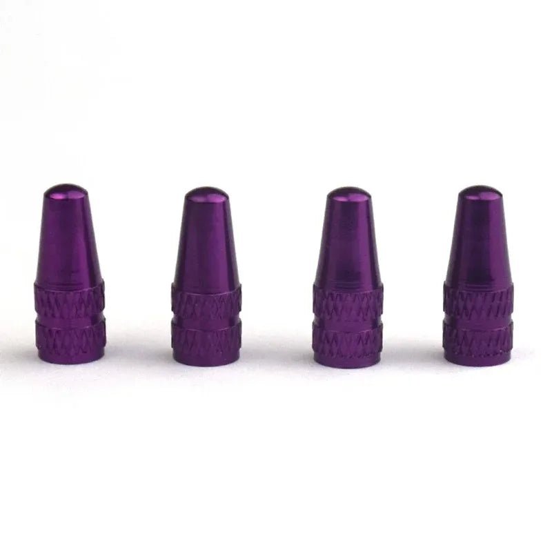 Four purple metal valve stem caps on a white background