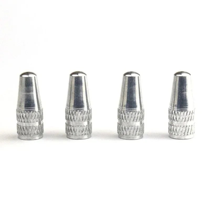Four metallic valve stem caps on a white background