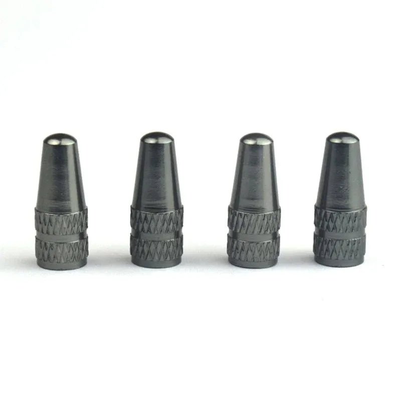 Four metallic valve stem caps on a white background